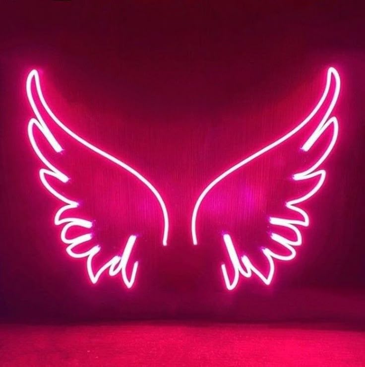 Neon pink wings with 'Wish' on a dark brick wall