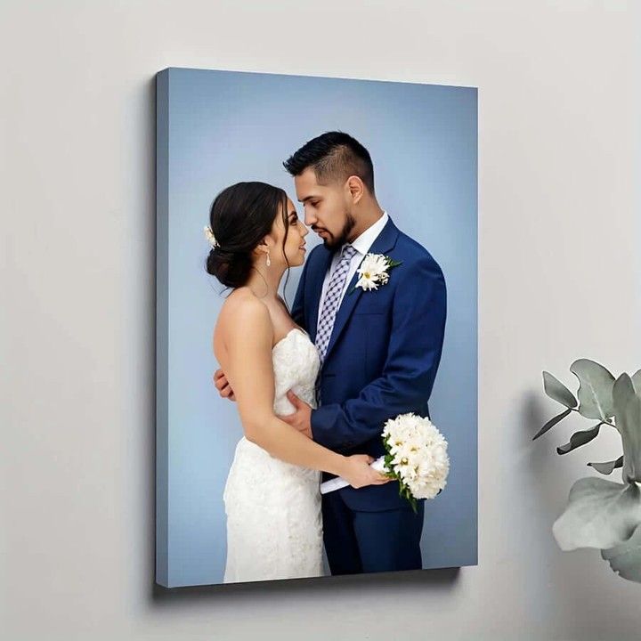 Canvas print of a bride and groom embracing with a light blue gradient background.