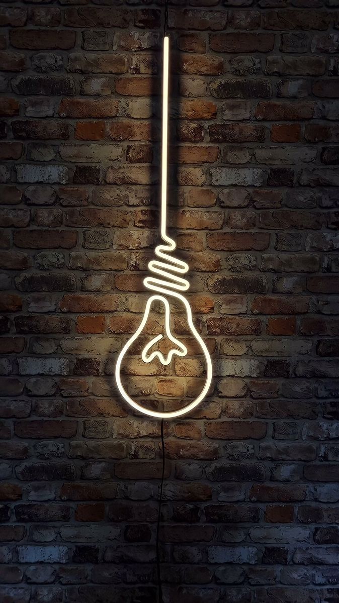 Neon light bulb sign on a brick wall