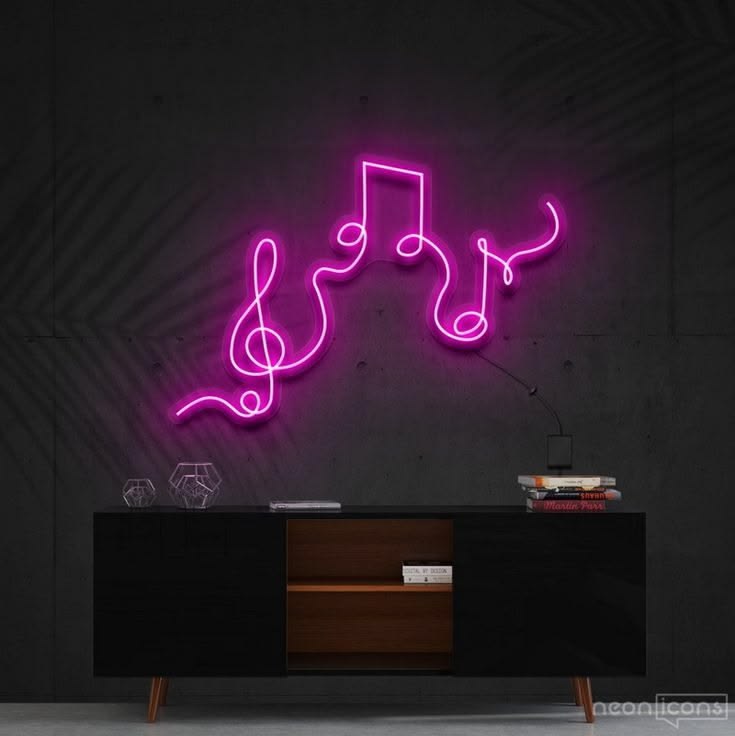 Neon sign shaped like musical notes on a dark wall with a piece of furniture below.